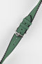 A diagonal close-up of a dark green Hirsch Arne Animal-Free Sailcloth Effect Performance watch strap with a polished silver pin buckle, set against a bright white background. The textured surface of the green strap and the black lining are clearly visible.