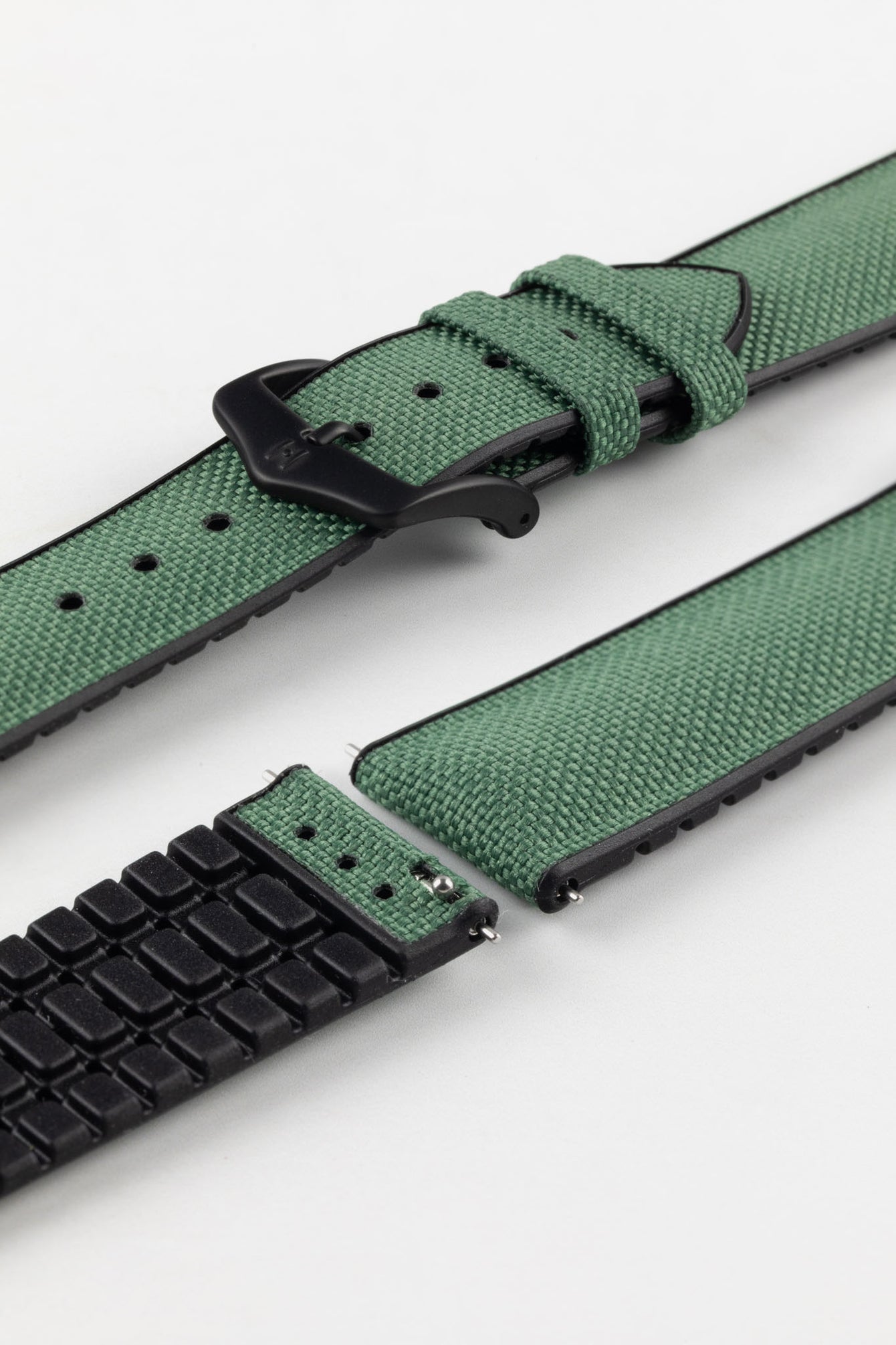 A Hirsch Arne Dark Green Animal-Free Sailcloth Effect Performance Watch Strap is displayed, showcasing the strap's full length and a matte black pin buckle. The textured sailcloth-like material of the dark green strap is clearly visible, along with the black rubberized underside.