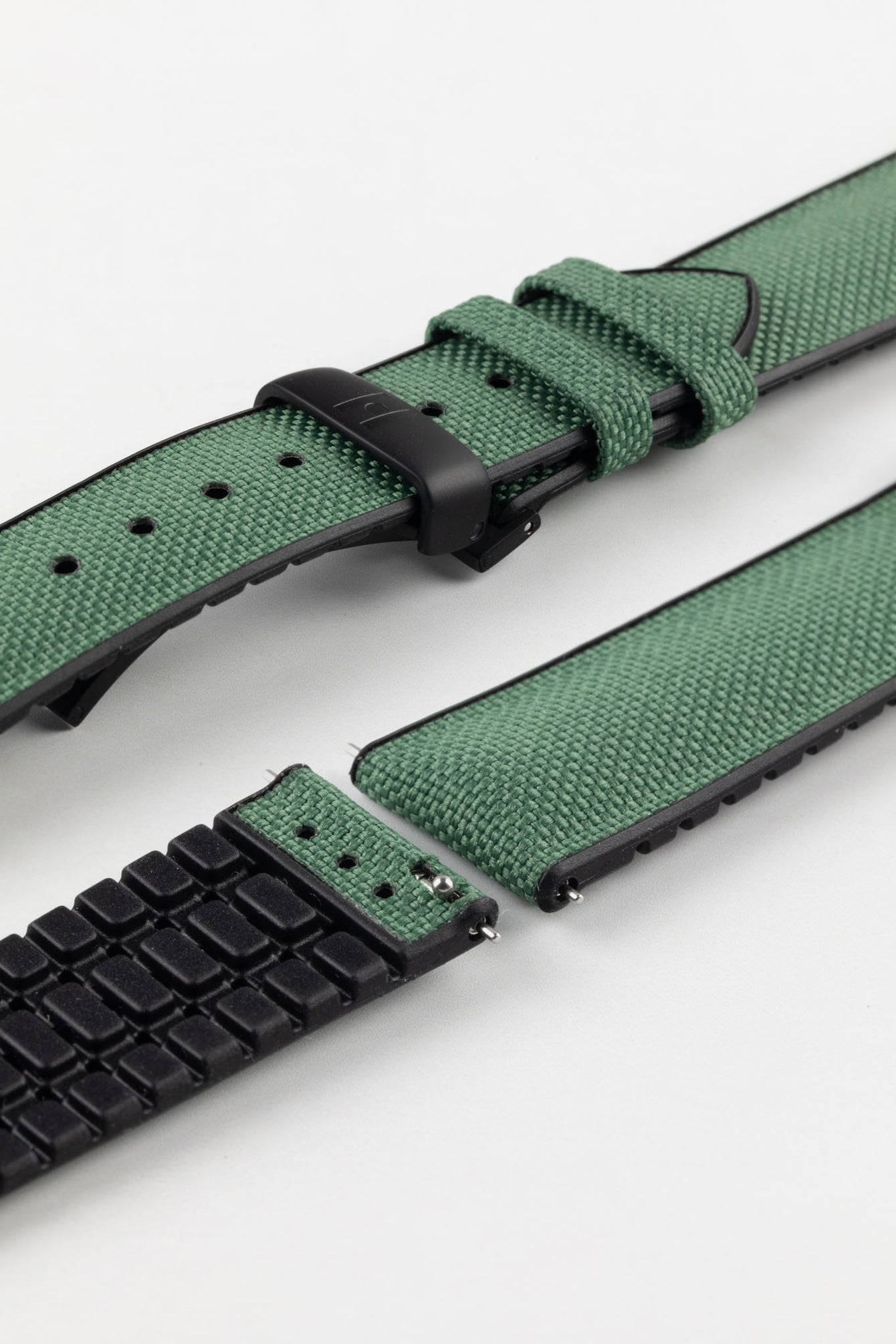 A Hirsch Arne Dark Green Animal-Free Sailcloth Effect Performance Watch Strap is displayed, showcasing the strap's full length and a matte black Deployment Clasp. The textured sailcloth-like material of the dark green strap is clearly visible, along with the black rubberized underside.