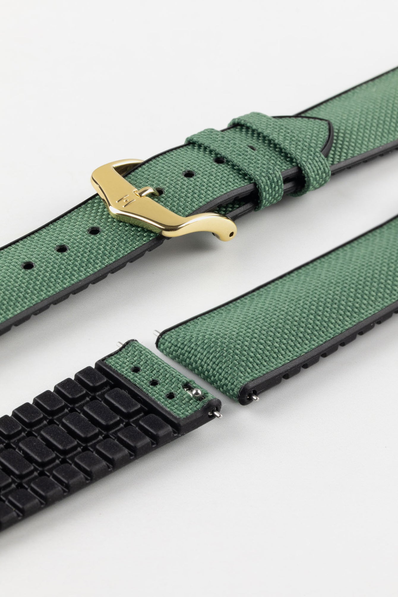 A Hirsch Arne Dark Green Animal-Free Sailcloth Effect Performance Watch Strap is displayed, showcasing the strap's full length and a gold pin buckle. The textured sailcloth-like material of the dark green strap is clearly visible, along with the black rubberized underside.