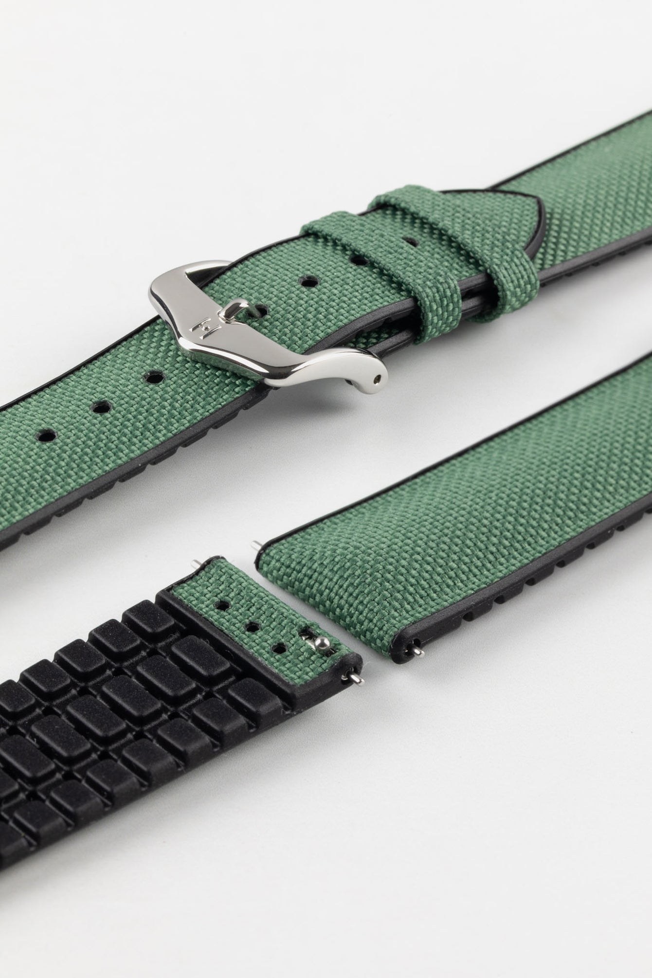 A Hirsch Arne Dark Green Animal-Free Sailcloth Effect Performance Watch Strap is displayed, showcasing the strap's full length and a polished silver pin buckle. The textured sailcloth-like material of the dark green strap is clearly visible, along with the black rubberized underside.