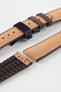 Golden brown textile-effect watch strap with brown rubber backing and a black deployment clasp, shown in separate sections on a white background. Features a woven-look surface, brown edges, and a patterned rubber underside.