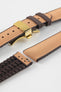 Golden brown textile-effect watch strap with brown rubber backing and a gold-tone deployment clasp, shown in separate sections on a white background. Features a woven-look surface, brown edges, and a patterned rubber underside.