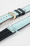 Ice blue textile-effect watch strap with black rubber backing and a rose gold-tone deployment clasp, shown in separate sections on a white background. Features a woven-look surface, black edges, and a patterned rubber underside.
