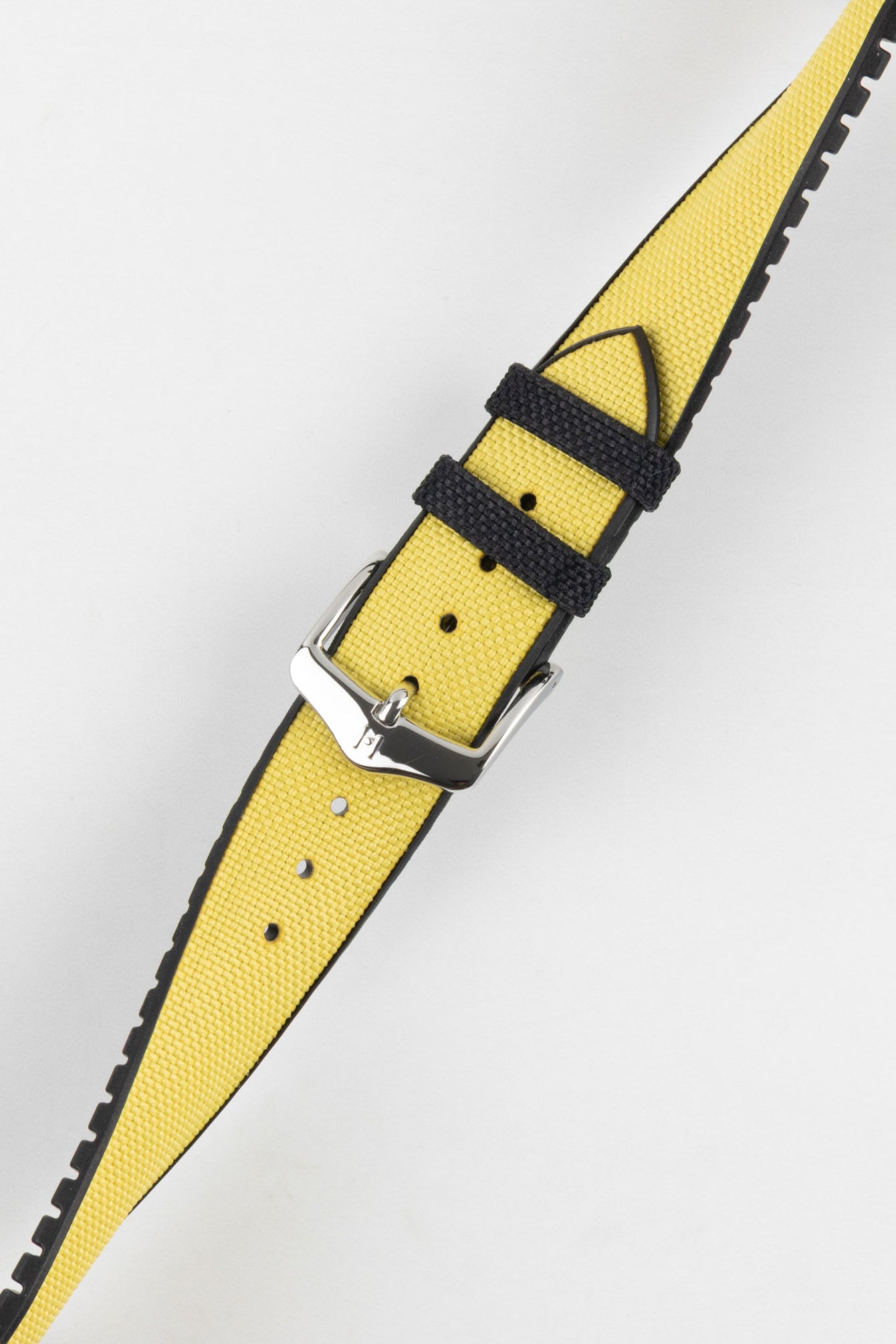 A diagonal close-up of a yellow Hirsch Arne Animal-Free Sailcloth Effect Performance watch strap with a polished silver pin buckle, set against a bright white background. The textured surface of the yellow strap with black keepers and the black lining are clearly visible.