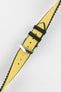 A diagonal close-up of a yellow Hirsch Arne Animal-Free Sailcloth Effect Performance watch strap with a polished silver pin buckle, set against a bright white background. The textured surface of the yellow strap with black keepers and the black lining are clearly visible.
