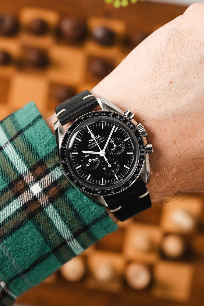 Black Omega Speedmaster Moonwatch fitted with Hirsch Bagnore Black Leather watch strap worn on wrist