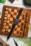 Luxury watch strap and watch combination on travel chess board.