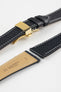 Black leather watch strap with a golden deployant clasp, shown with a beige leather underside and white contrast stitching.