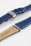 Blue leather watch strap with a stainless steel deployant clasp, shown with a beige leather underside and white contrast stitching.