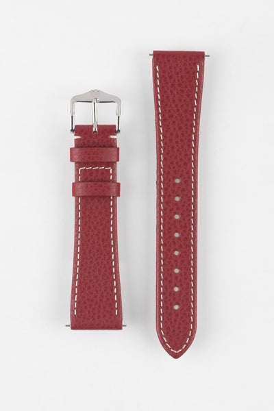 Product shot of a red textured leather watch strap displayed against a white background, showing both sections side by side: one with a polished silver-tone pin buckle and two keepers, and the other with a pointed tip and multiple adjustment holes, highlighting the white contrast stitching and subtle grain pattern.