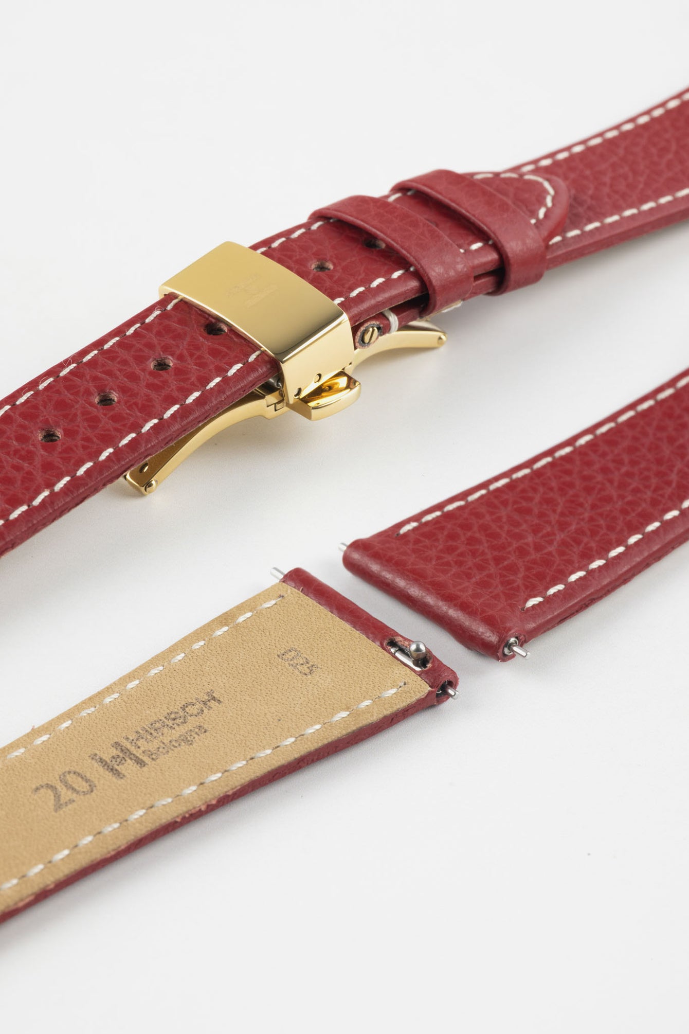 Burgundy leather watch strap with a golden deployant clasp, shown with a beige leather underside and white contrast stitching.