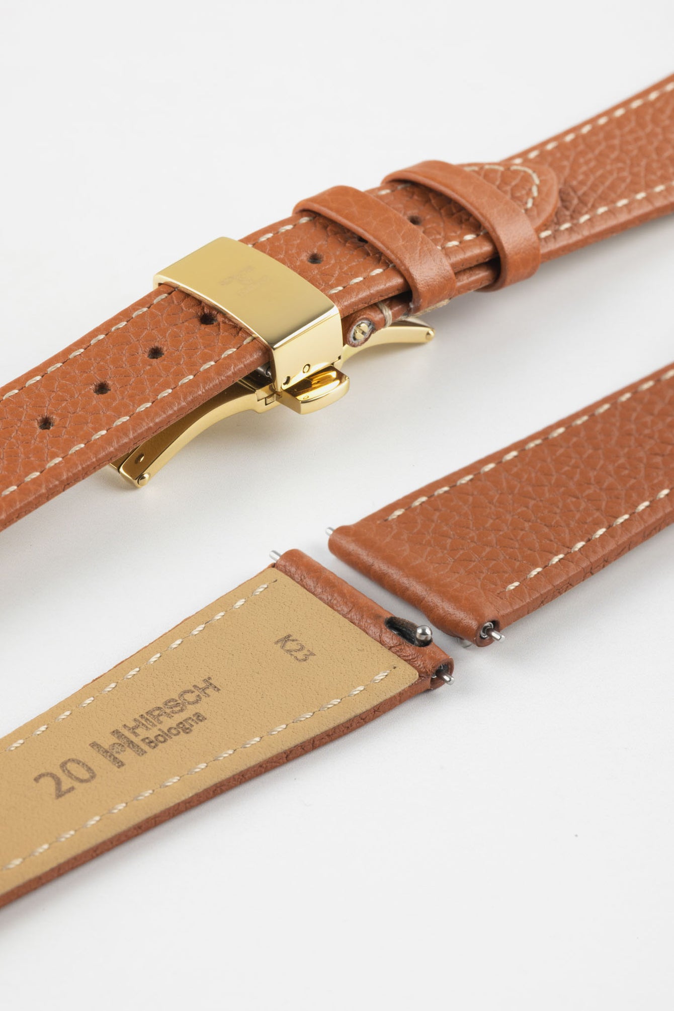 Gold brown leather watch strap with a golden deployant clasp, shown with a beige leather underside and white contrast stitching.