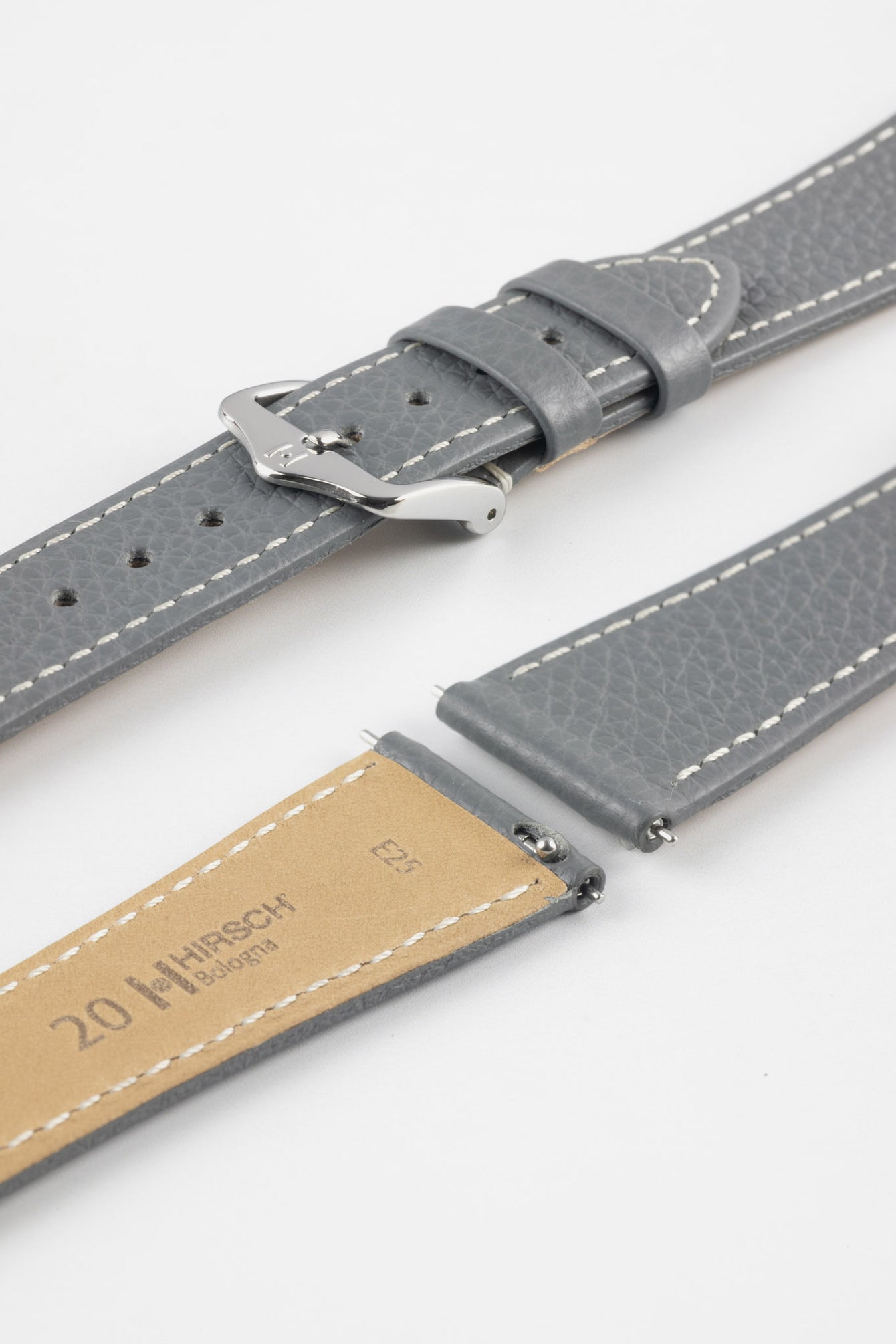 Close-up product image of a grey textured leather watch strap with white contrast stitching, displayed against a white background, featuring a polished silver-tone pin buckle and two keepers, alongside separate strap sections with exposed spring bars and a beige underside stamped with partial text “20 HIRSCH Bologna.”
