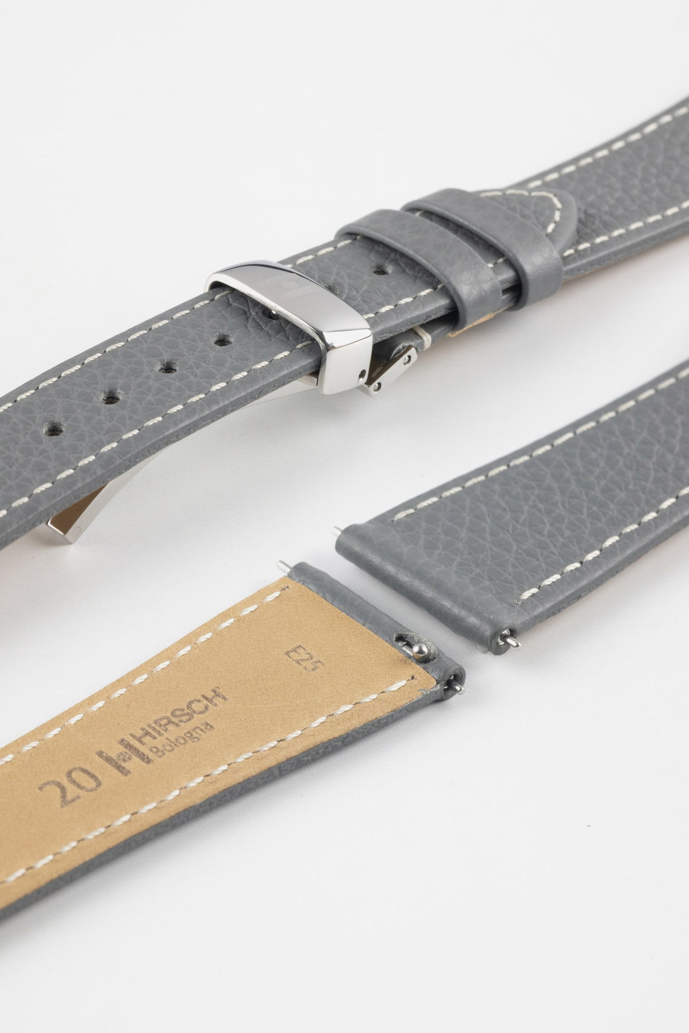 Close-up product image of a grey textured leather watch strap with white contrast stitching, displayed against a white background, featuring a polished silver-tone folding clasp and two keepers, alongside separate strap sections with exposed spring bars and a beige underside stamped with partial text “20 HIRSCH Bologna.”