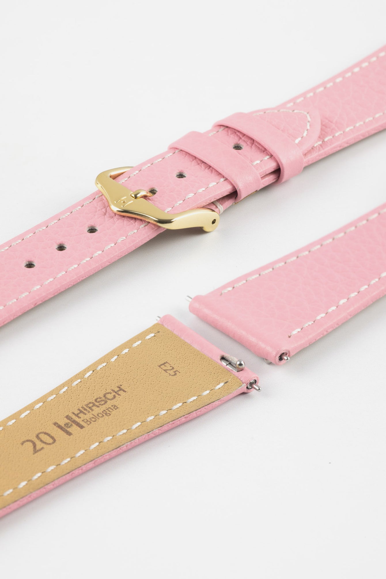 Close-up product image of a pink textured leather watch strap with white contrast stitching, displayed on a white background, featuring a polished gold-tone pin buckle and two keepers, alongside separate strap sections with exposed spring bars and a beige underside stamped “HIRSCH Bologna 20.”