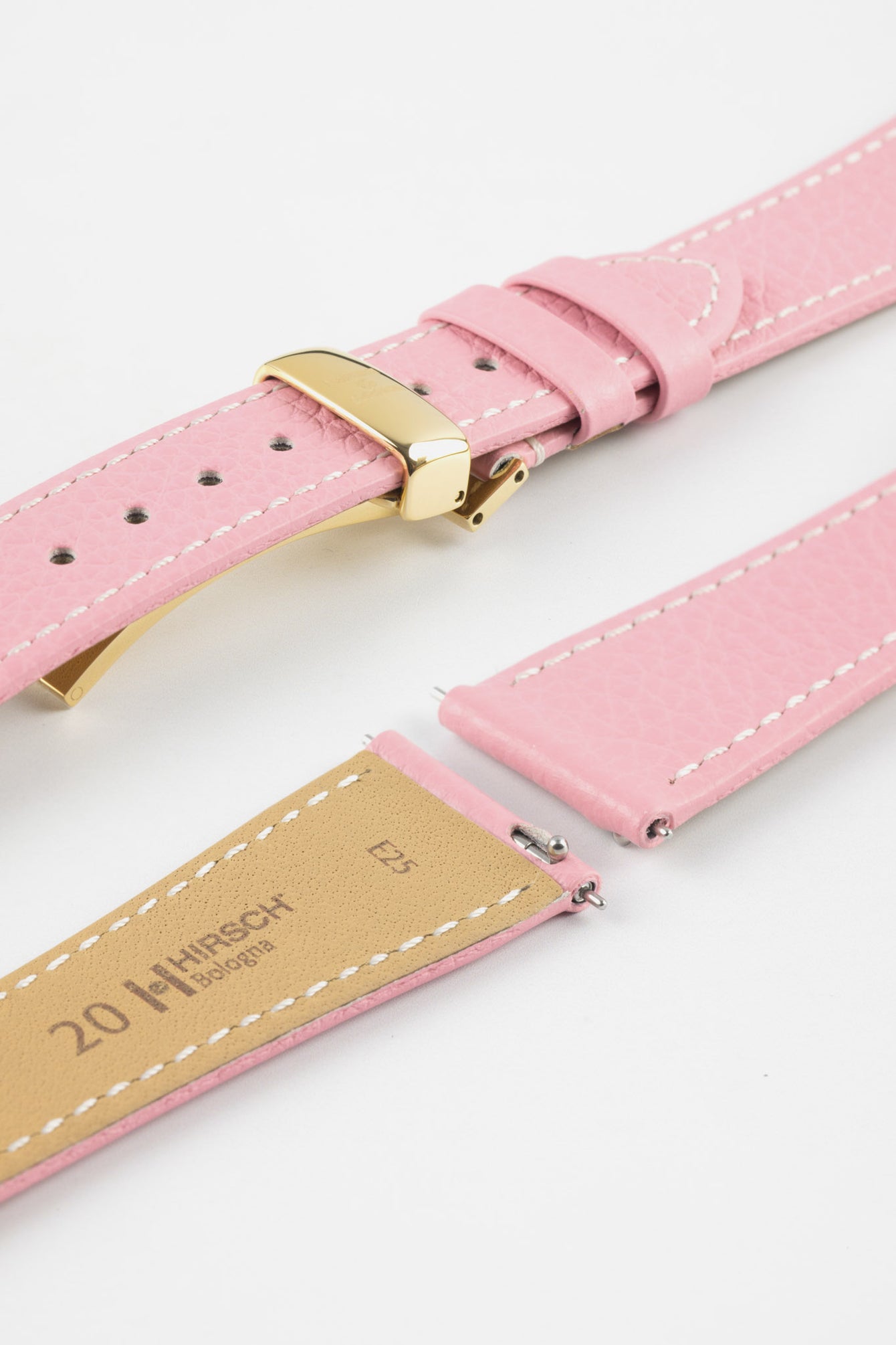 Close-up product image of a pink textured leather watch strap with white contrast stitching, displayed against a white background, featuring a polished gold-tone folding clasp and two keepers, alongside separate strap sections with exposed spring bars and a beige underside stamped “HIRSCH Bologna 20.”