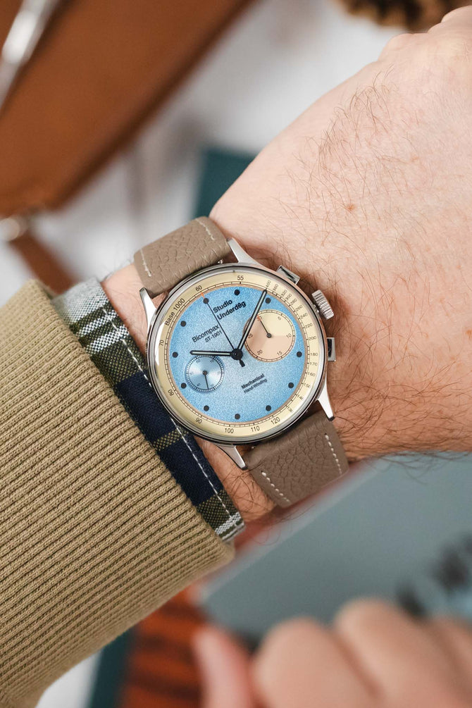 Taupe Hirsch Bologna leather watch strap fitted to Studio Underd0g Desert Sky timepiece worn on wrist with jumper and shirt