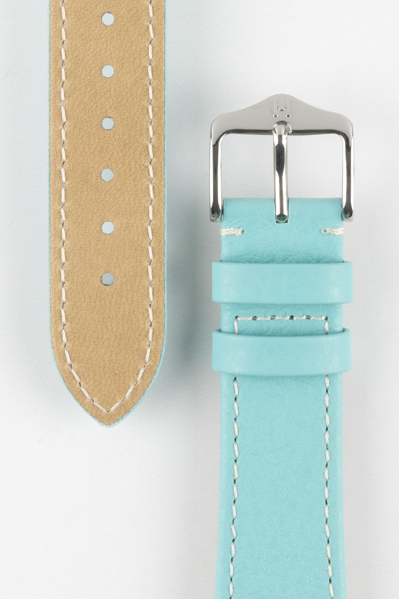 Close-up product image of a light turquoise-blue leather watch strap against a white background, showing the underside with multiple adjustment holes and beige lining on one section, and the other with a polished silver-tone pin buckle and two keepers, highlighting the white contrast stitching and fine textured grain.