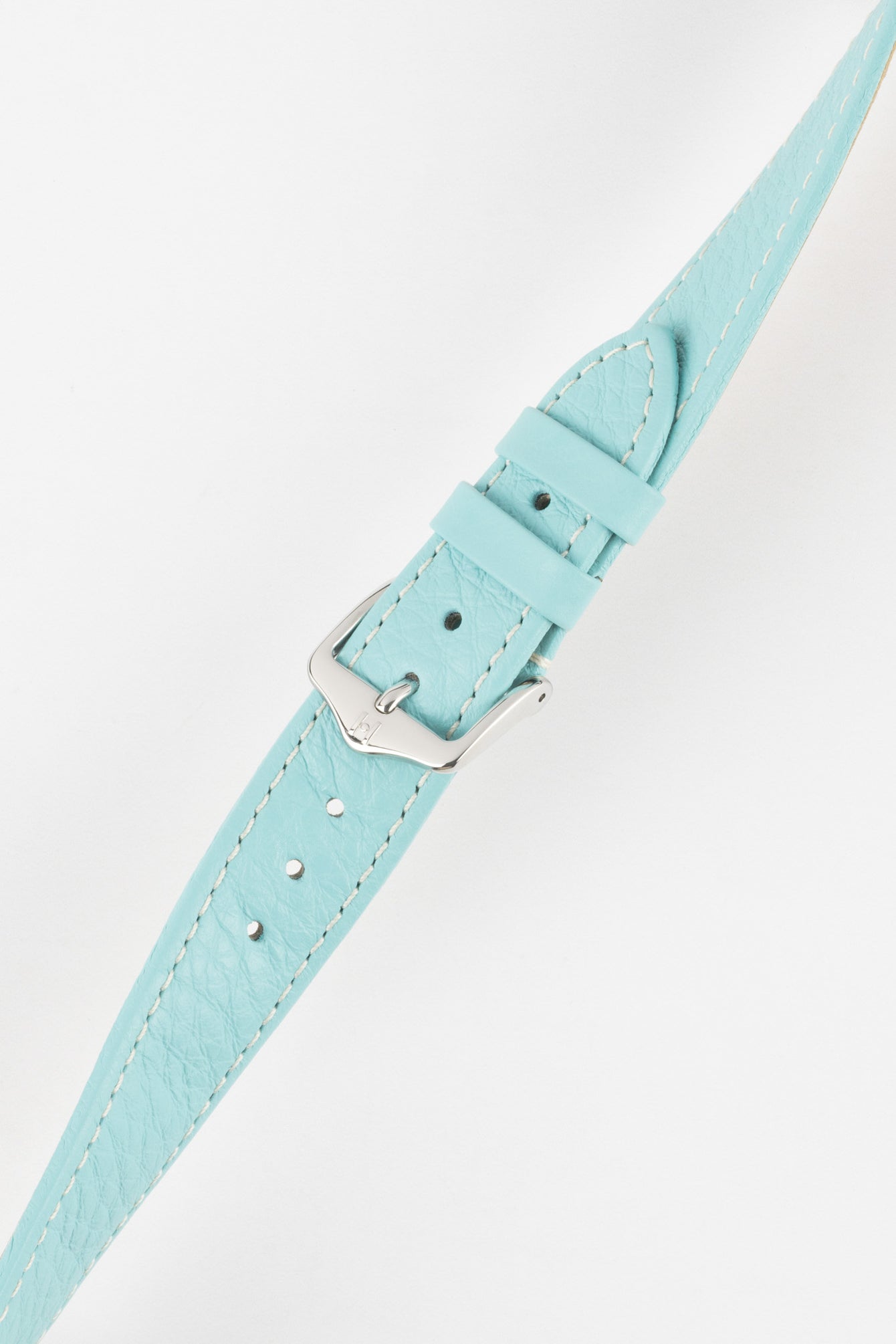 Close-up of a light turquoise-blue textured leather watch strap with white contrast stitching, featuring a polished silver-tone pin buckle and two keepers, with visible adjustment holes and a lightly grained finish against a white background.