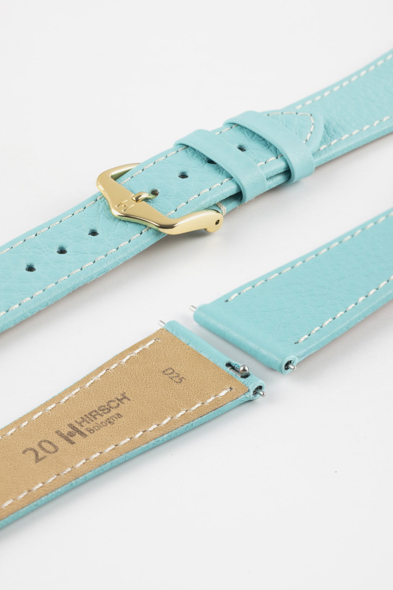 Close-up product image of a light turquoise-blue textured leather watch strap with white contrast stitching, displayed against a white background, featuring a polished gold-tone pin buckle and two keepers, alongside separate strap sections with exposed spring bars and a beige underside stamped with partial text “20 HIRSCH Bologna.”