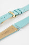 Close-up product image of a light turquoise-blue textured leather watch strap with white contrast stitching, displayed on a white background, featuring a polished gold-tone folding clasp and two keepers, alongside separate strap sections with exposed spring bars and a beige underside stamped with partial text “20 HIRSCH Bologna.”