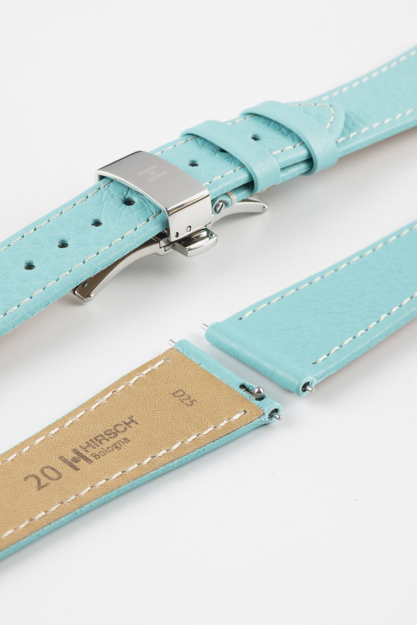 Close-up of a turquoise leather watch strap with white stitching and a polished silver butterfly clasp, shown open alongside detached strap ends with visible spring bars on a clean white background.