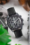 OMEGA x Swatch MoonSwatch Mission to the Moon watch on a black textured leather strap, white stitching, lifestyle shot.