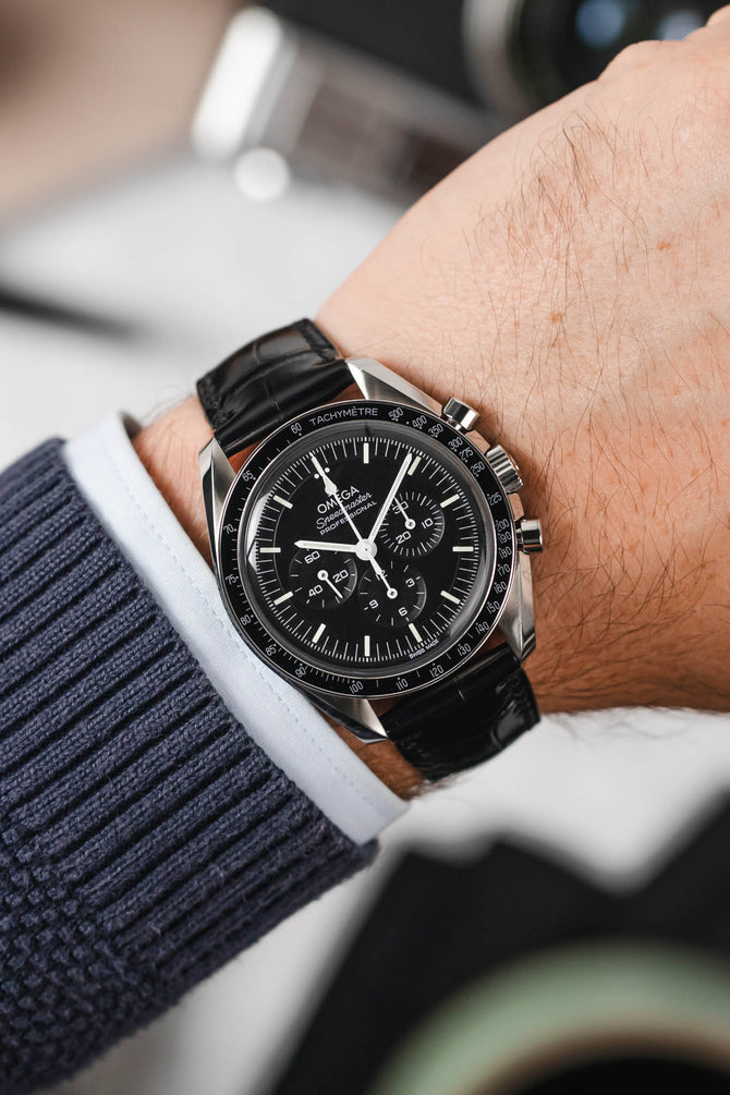 Black Omega Speedmaster Moonwatch fitted with Hirsch London black leather watch strap worn on wrist