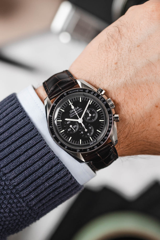 Black Omega Speedmaster Moonwatch fitted with Hirsch London brown leather watch strap worn on wrist