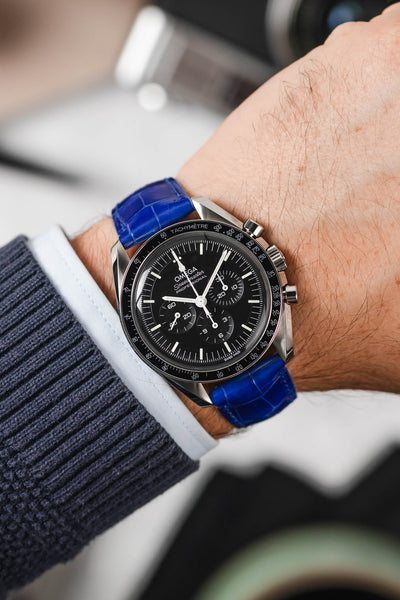 Black Omega Speedmaster Moonwatch fitted with Hirsch London royal blue leather watch strap worn on wrist