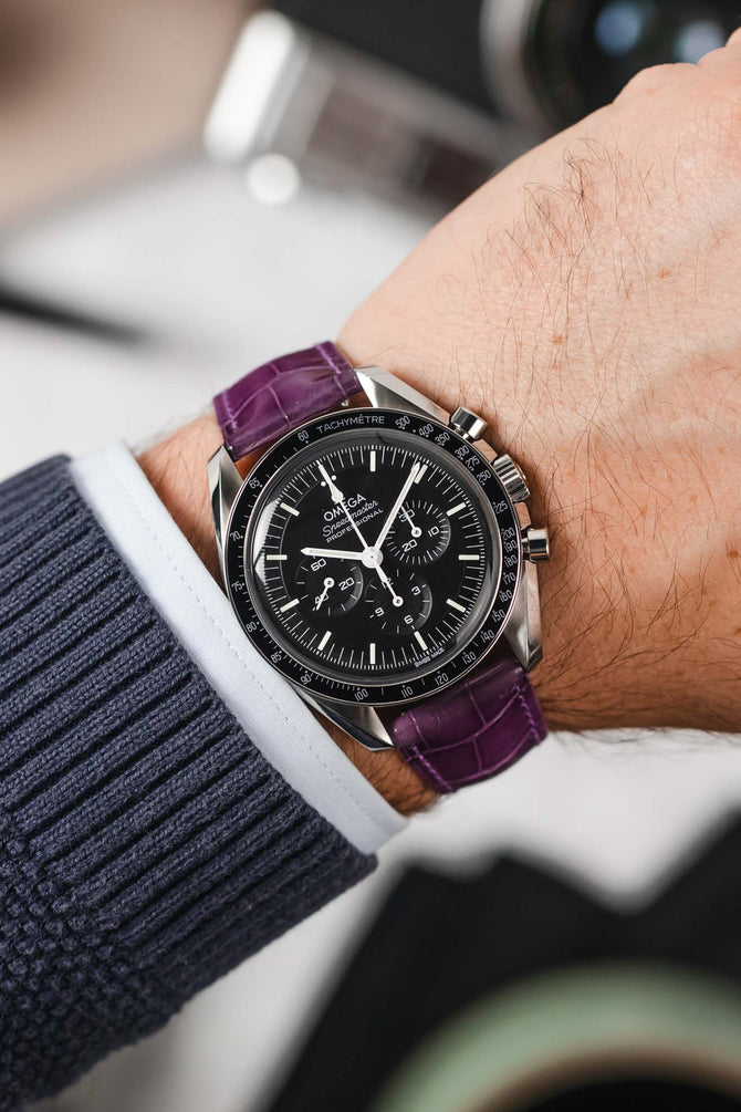 Black Omega Speedmaster Moonwatch fitted with Hirsch London violet leather watch strap worn on wrist