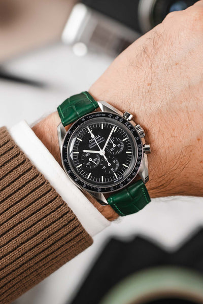 Black Omega Speedmaster Moonwatch fitted with Hirsch London Dark Green Alligator Leather watch strap worn on wrist