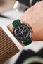 Black Omega Speedmaster Moonwatch fitted with Hirsch London Dark Green Alligator Leather watch strap worn on wrist