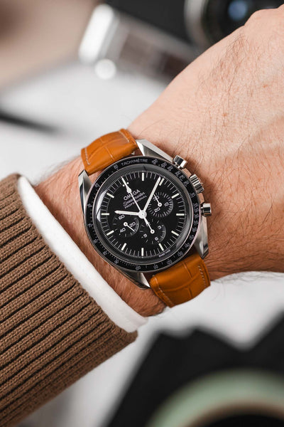 Black Omega Speedmaster moonwatch fitted with Hirsch London Alligator honey leather watch strap worn on wrist