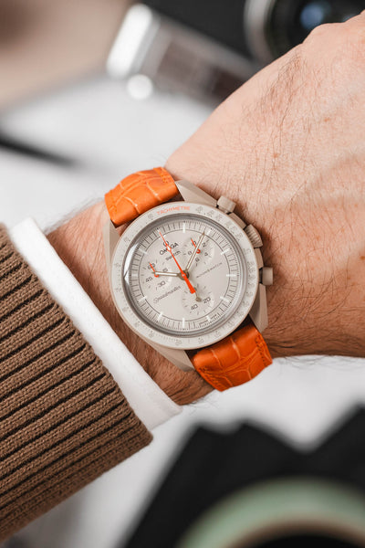 Omega Moonswatch Jupiter fitted with Hirsch London Orange alligator watch strap worn on wrist