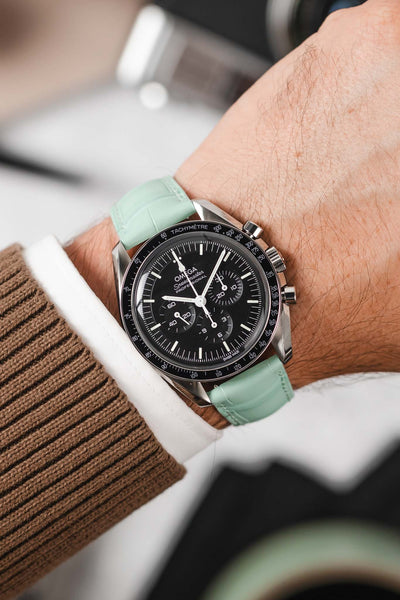 Black Omega Speedmaster moonwatch fitted with Hirsch London Alligator pastel blue leather watch strap worn on wrist