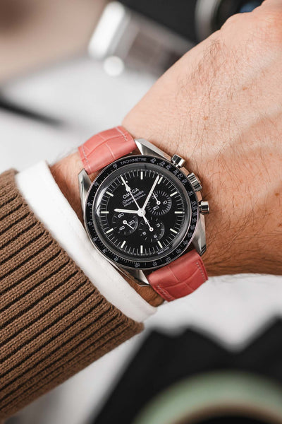 Black Omega Speedmaster moonwatch fitted with Hirsch London Alligator pink leather watch strap worn on wrist