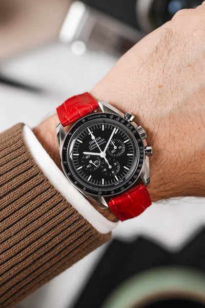 Black Omega Speedmaster moonwatch fitted with Hirsch London Alligator red leather watch strap worn on wrist