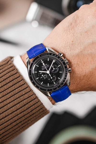 Black Omega Speedmaster moonwatch fitted with Hirsch London Alligator royal blue leather watch strap worn on wrist