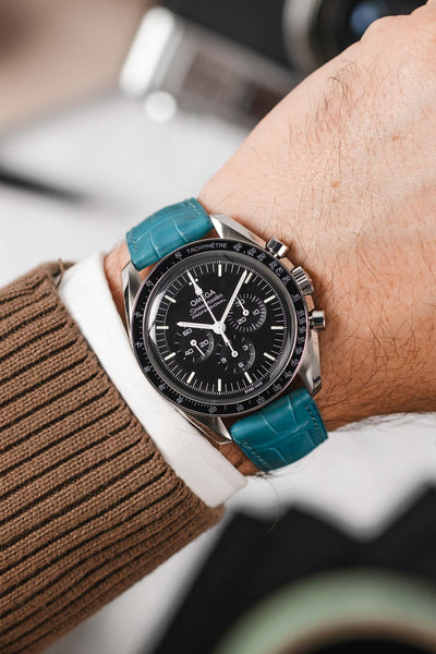 Black Omega Speedmaster Moonwatch fitted with Hirsch London turquoise Alligator Leather watch strap worn on wrist