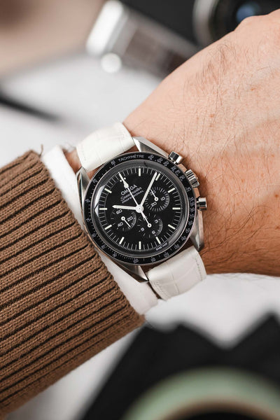 Black Omega Speedmaster Moonwatch fitted with Hirsch London white Alligator Leather watch strap worn on wrist