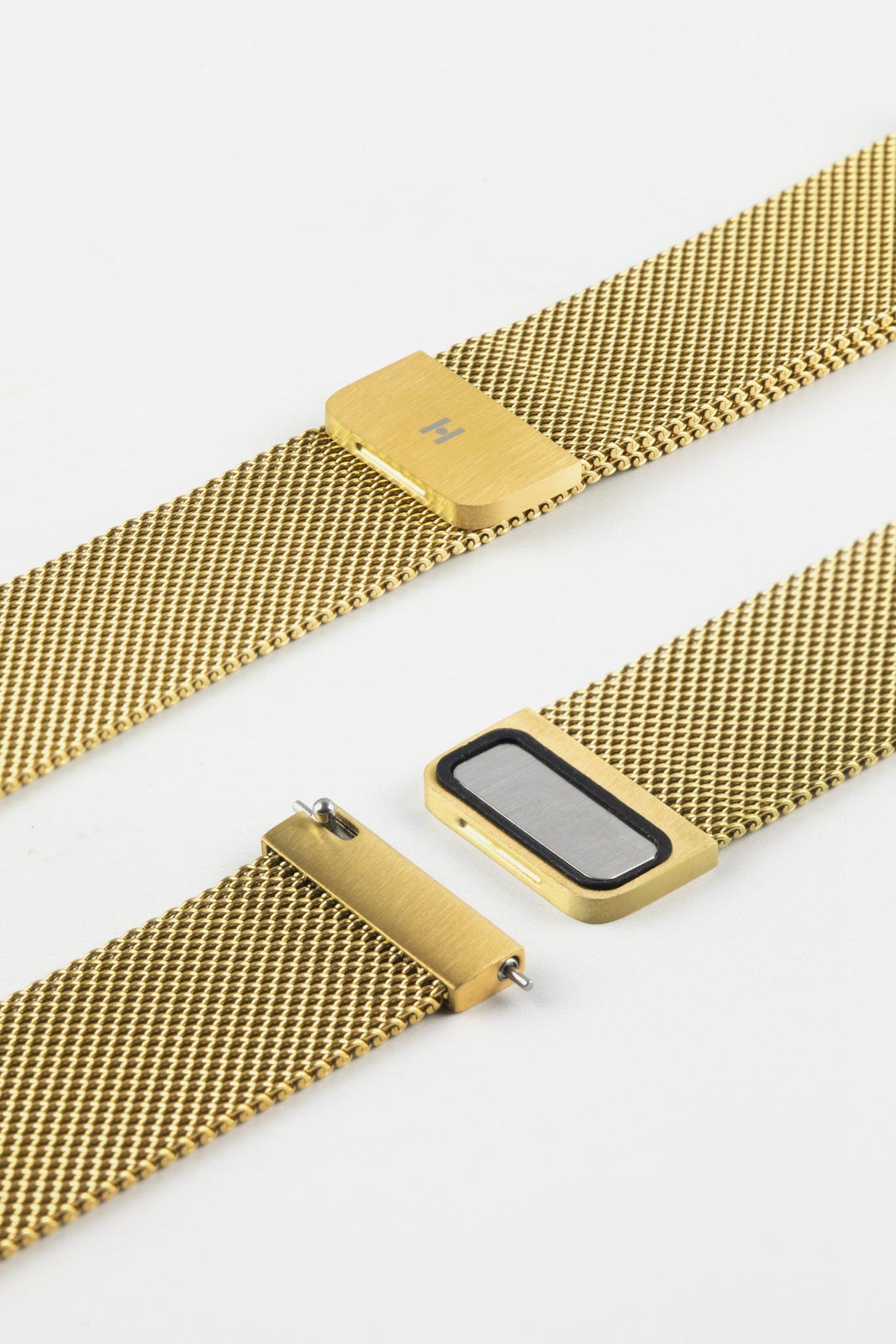 Close-up product image of a gold mesh watch strap against a white background, showing the adjustable sliding clasp and fastening mechanism in detail, with a fine woven texture and brushed gold finish visible on the hardware.