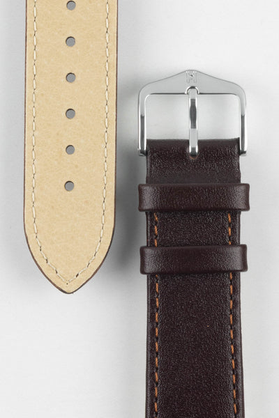 Premium dark brown Hirsch Osiris leather watch strap featuring a smooth semi-gloss leather finish, contrasting tan stitching, padded construction, beige genuine leather lining, dual leather keepers, and a polished stainless steel Hirsch buckle. Detailed product close-up showcasing exceptional craftsmanship, lasting comfort, durable construction, and timeless styling for dress, business, luxury, and everyday watches.