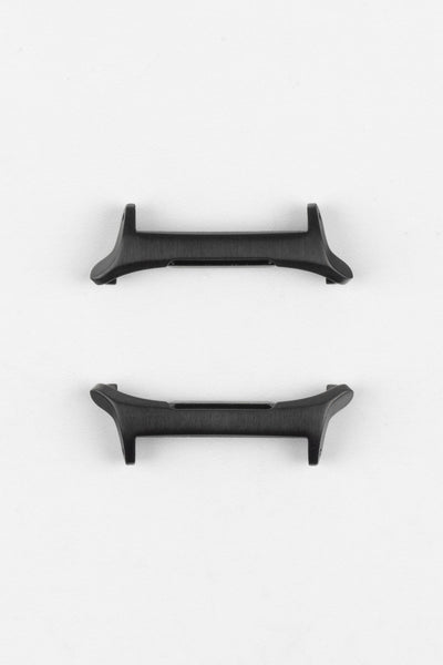 Two black smartwatch strap adapters with a matte finish, shown from different angles on a light grey background.