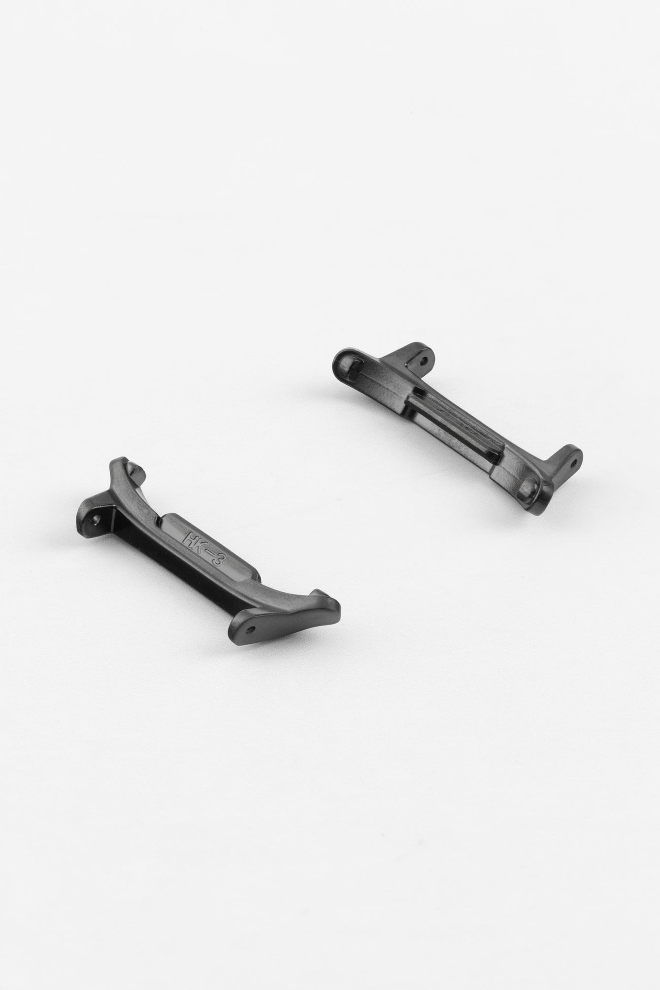 Two black smartwatch strap adapters with a matte finish, shown at an angle on a light grey background, highlighting their curved ends and attachment slots.