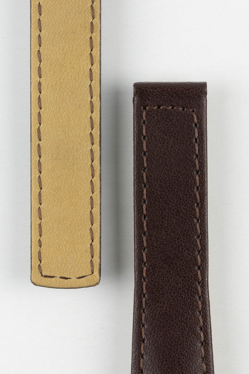 Close-up of a dark brown calf leather watch strap showing the front and beige underside on a light gray background. The strap features a smooth leather finish, matching brown stitching, and padded construction, highlighting the quality materials and craftsmanship.