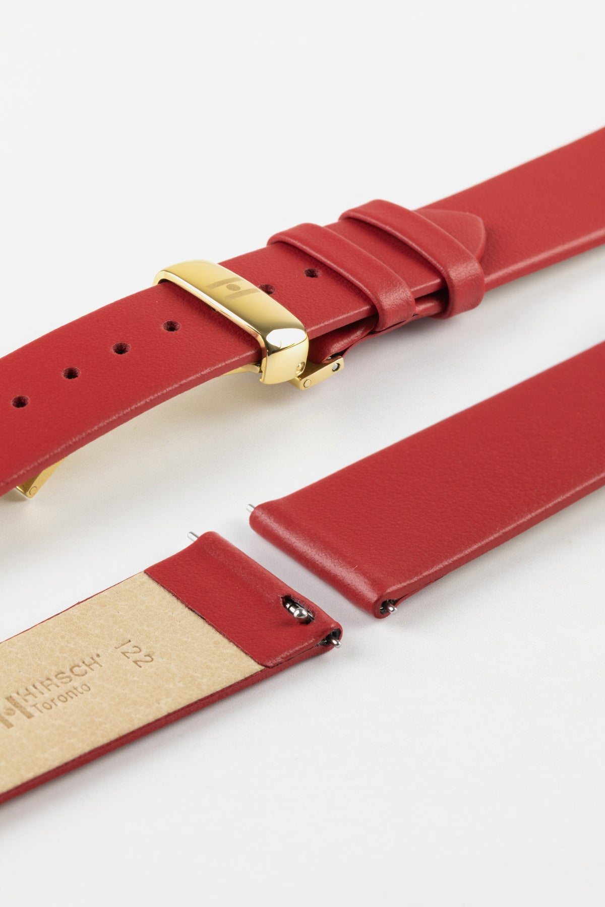 Close-up of a red leather watch strap displayed partially disassembled to showcase its integrated quick-release spring bars, cream leather lining, smooth leather surface, matching red edge finishing, and gold-tone deployant clasp. The image highlights the strap’s premium craftsmanship, easy strap-change system, and elegant dress-watch styling against a clean white background.