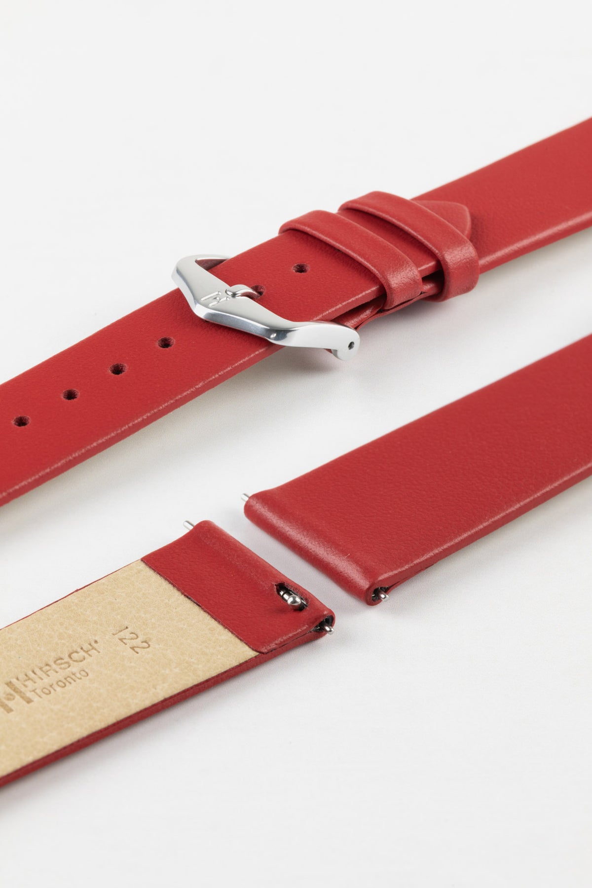 Close-up of a red leather watch strap displayed partially disassembled to showcase its integrated quick-release spring bars, smooth leather surface, matching red edge finishing, cream leather lining, and polished stainless steel pin buckle. The image highlights the strap’s premium craftsmanship, easy strap-change system, and clean contemporary styling against a white background.