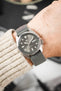 Seiko 5 Sports watch with a grey dial on a HIRSCH Vocem Grey strap, worn on a wrist over a knit sweater.